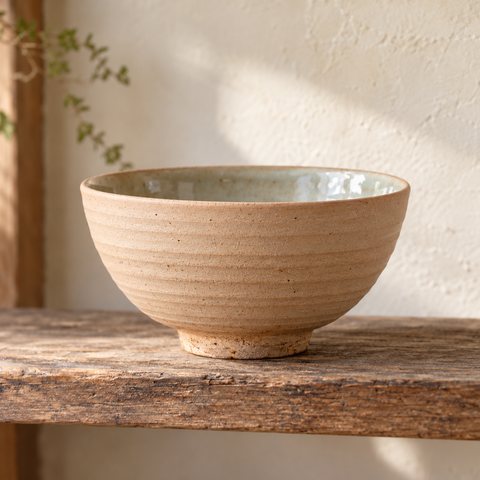 An unglazed stoneware bowl, sanded smooth outside, with a glazed interior.